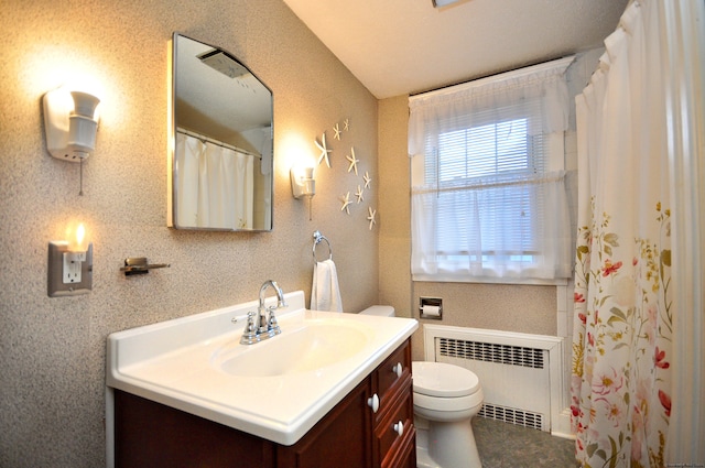 bathroom featuring toilet, radiator, and vanity