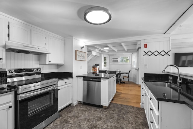 kitchen with dark countertops, a peninsula, stainless steel appliances, under cabinet range hood, and a sink