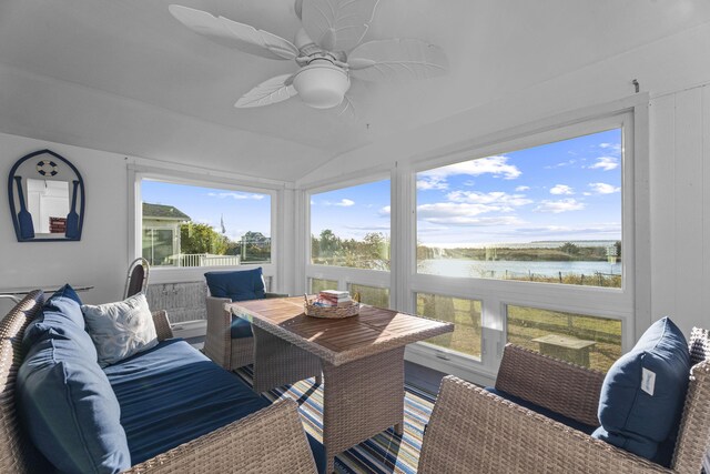 sunroom with ceiling fan, plenty of natural light, a water view, and vaulted ceiling