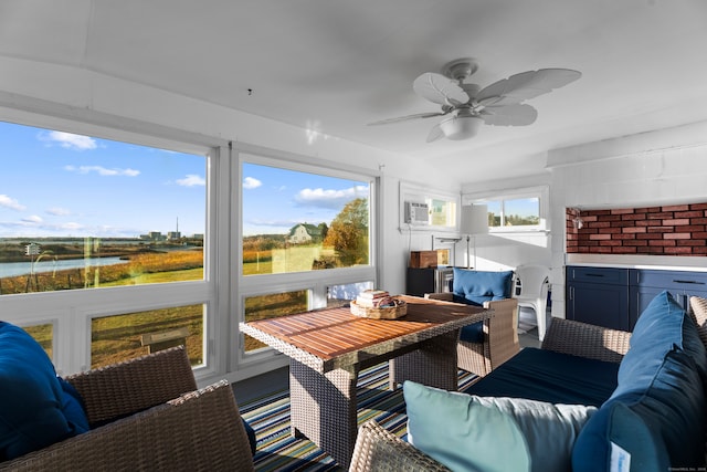 sunroom with a wall unit AC, ceiling fan, a water view, and vaulted ceiling