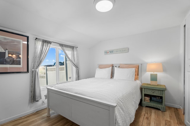 bedroom featuring vaulted ceiling and light hardwood / wood-style flooring