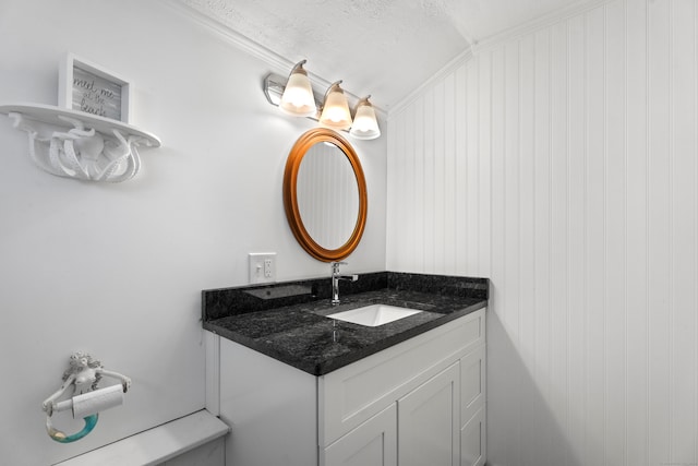 bathroom featuring wood walls, a textured ceiling, lofted ceiling, vanity, and ornamental molding