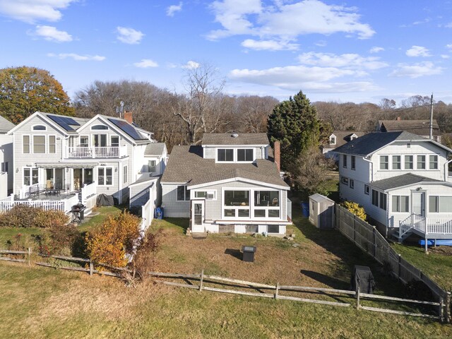 rear view of house featuring a balcony and solar panels