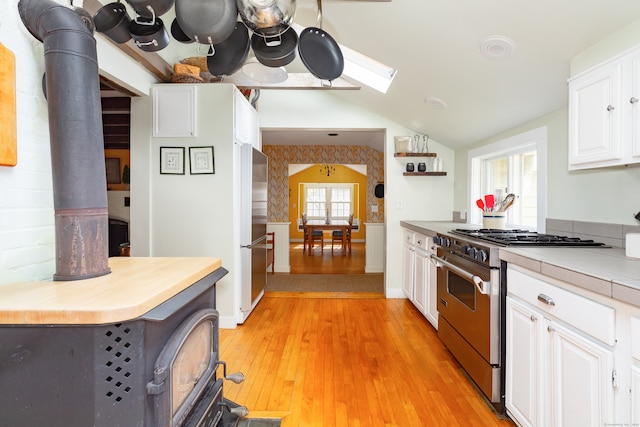 kitchen featuring light hardwood / wood-style flooring, white cabinetry, a wealth of natural light, and stainless steel appliances