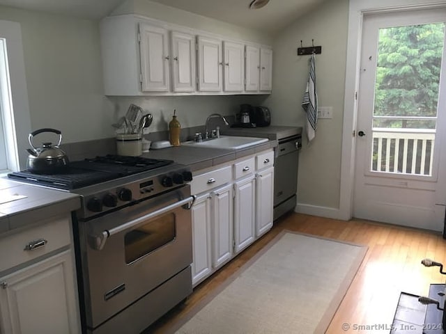 kitchen featuring white cabinets, appliances with stainless steel finishes, tile countertops, and sink