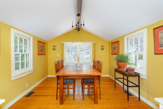 dining space featuring plenty of natural light, light hardwood / wood-style flooring, vaulted ceiling with beams, and a notable chandelier