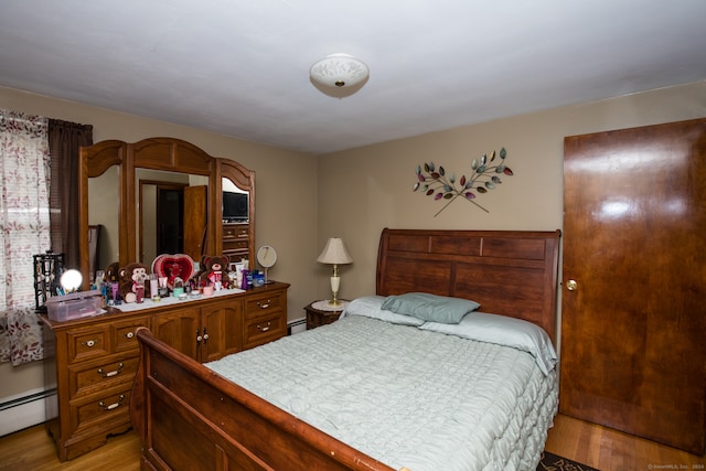 bedroom featuring light wood-type flooring and baseboard heating