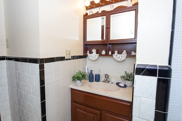 bathroom featuring vanity and tile walls