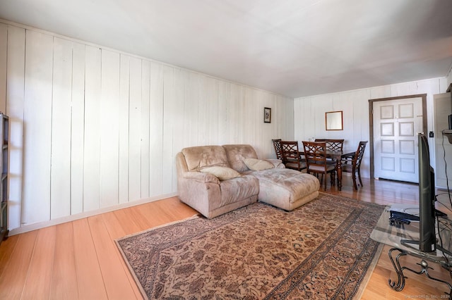 living room with wood-type flooring and wooden walls