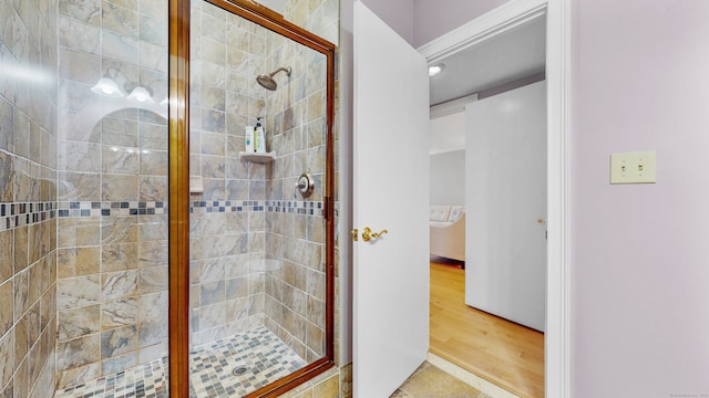 bathroom featuring hardwood / wood-style floors and a shower with door