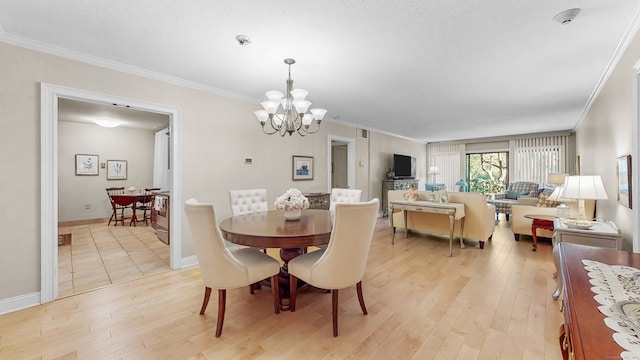 dining space with a chandelier, light hardwood / wood-style floors, and crown molding