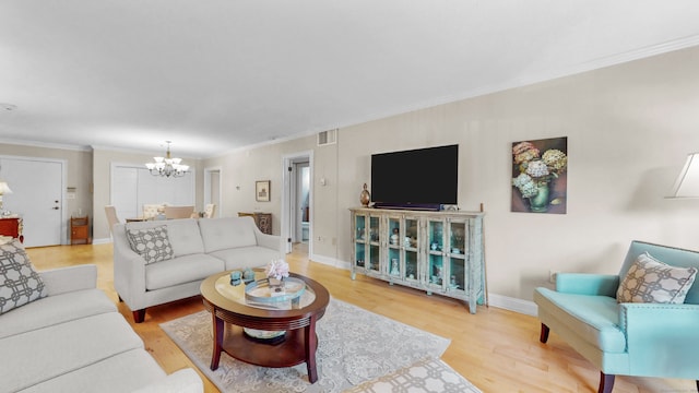 living room featuring ornamental molding, hardwood / wood-style floors, and a chandelier