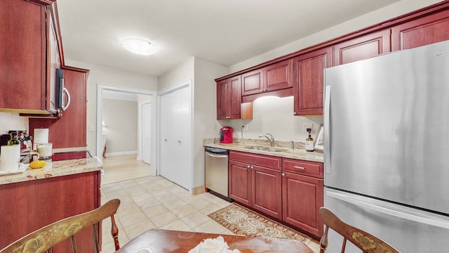 kitchen with stainless steel appliances, light tile patterned floors, sink, and light stone counters