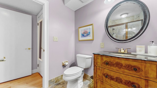 bathroom featuring walk in shower, vanity, hardwood / wood-style flooring, and toilet