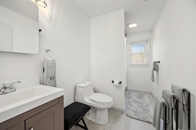 bathroom featuring tile patterned flooring, vanity, and toilet