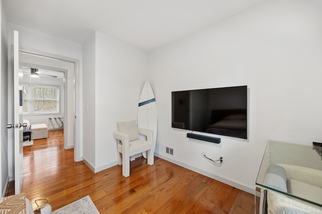 sitting room with hardwood / wood-style flooring and ceiling fan