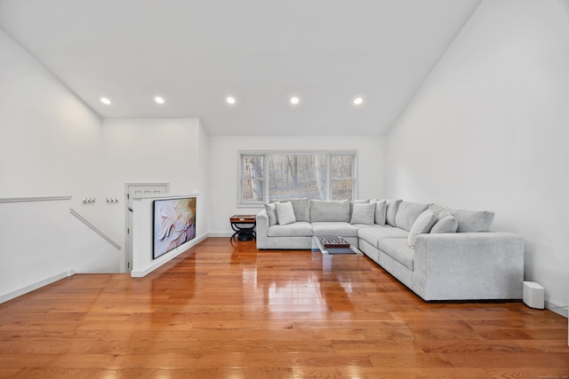 living room featuring high vaulted ceiling and light wood-type flooring