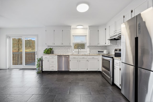 kitchen with backsplash, white cabinets, sink, light stone counters, and stainless steel appliances