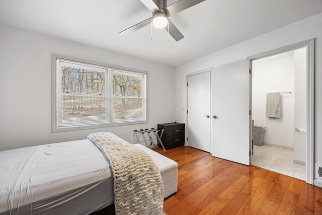 bedroom with connected bathroom, light hardwood / wood-style flooring, and ceiling fan