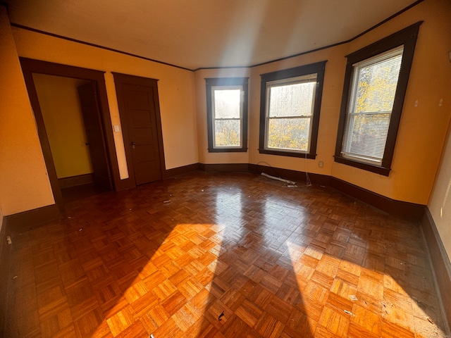 unfurnished room featuring parquet flooring and a healthy amount of sunlight