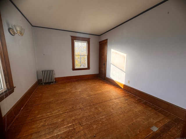 empty room featuring hardwood / wood-style flooring and radiator