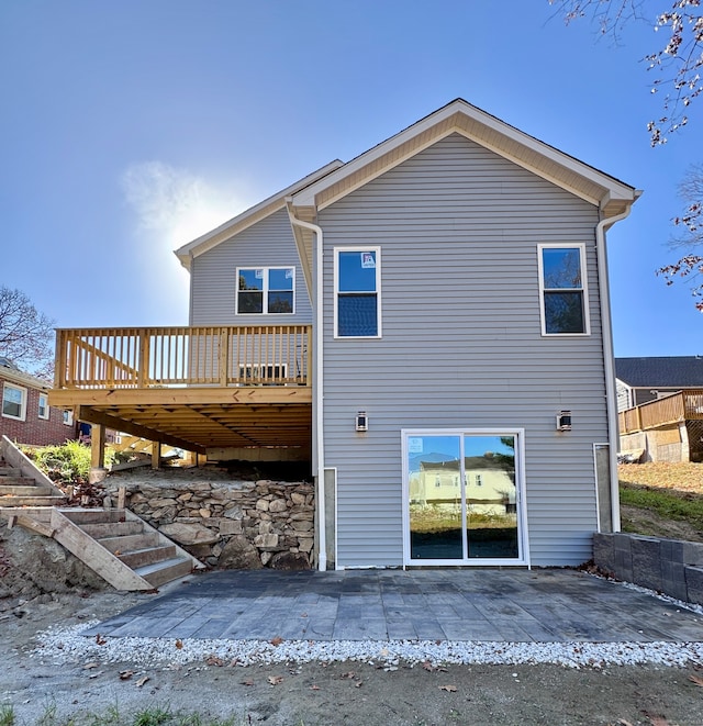 rear view of property with a deck and a patio area