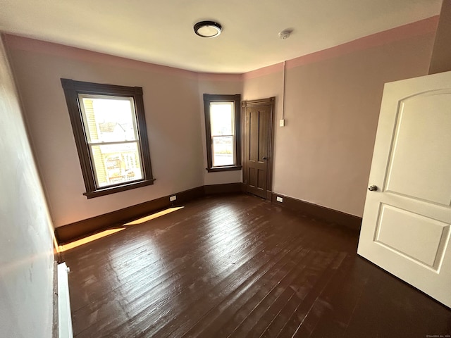 spare room with dark wood-type flooring