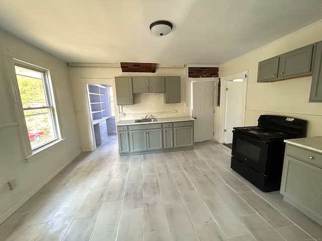 kitchen featuring light wood-type flooring, black / electric stove, and sink