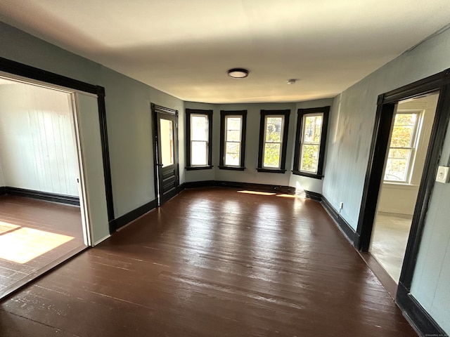 unfurnished room with a healthy amount of sunlight and dark hardwood / wood-style floors