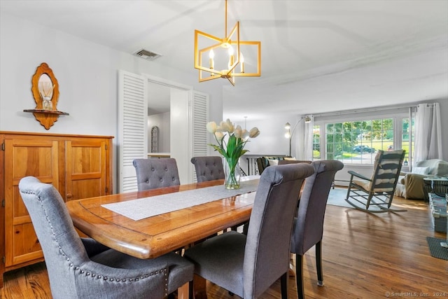 dining space with dark hardwood / wood-style flooring and a chandelier