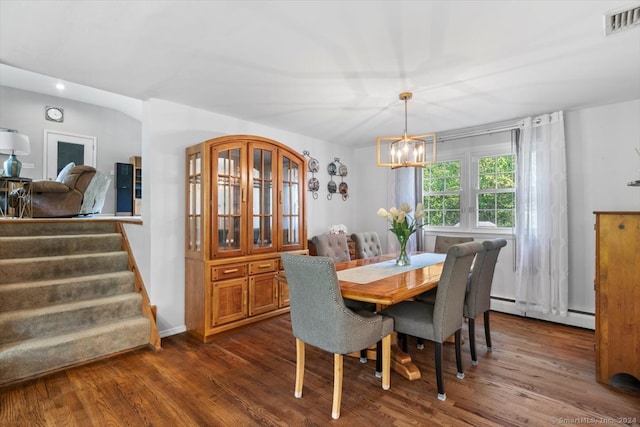 dining space with a baseboard radiator, dark hardwood / wood-style flooring, and an inviting chandelier