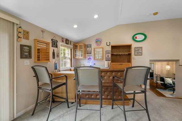 bar featuring light carpet and vaulted ceiling