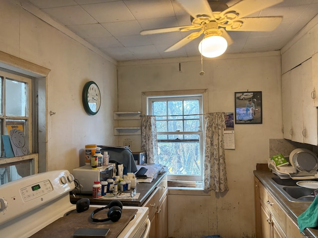 kitchen with white range oven, sink, and ceiling fan