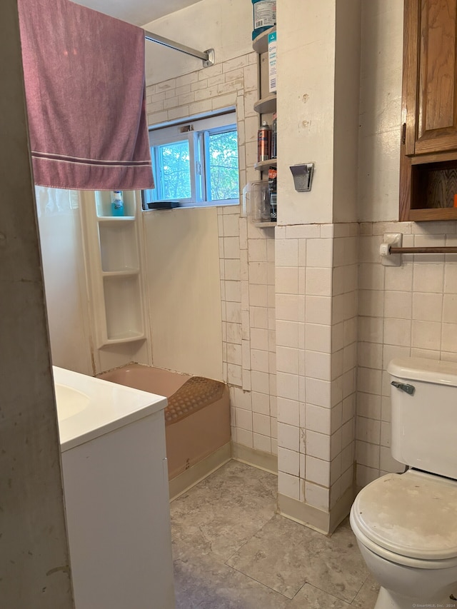 bathroom featuring toilet, vanity, tile walls, and a shower