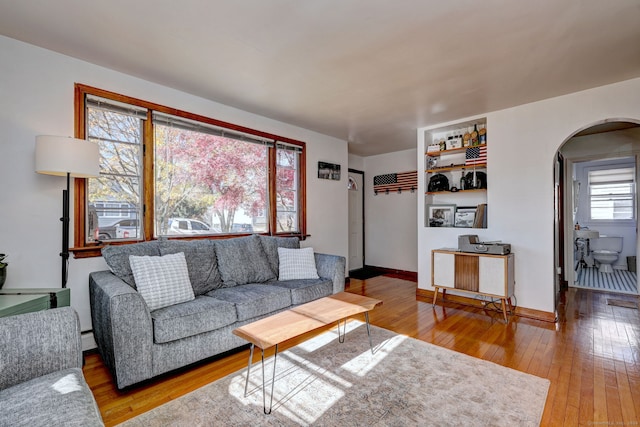 living room with wood-type flooring and a baseboard heating unit