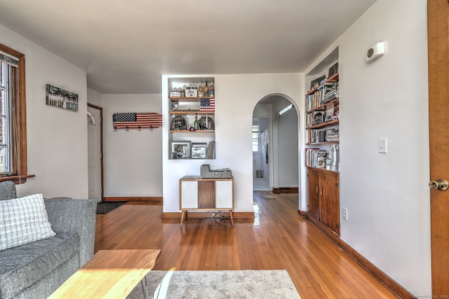 living room featuring hardwood / wood-style flooring and built in shelves