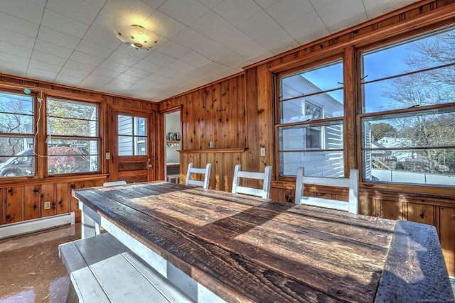 dining space with wooden walls and a baseboard radiator