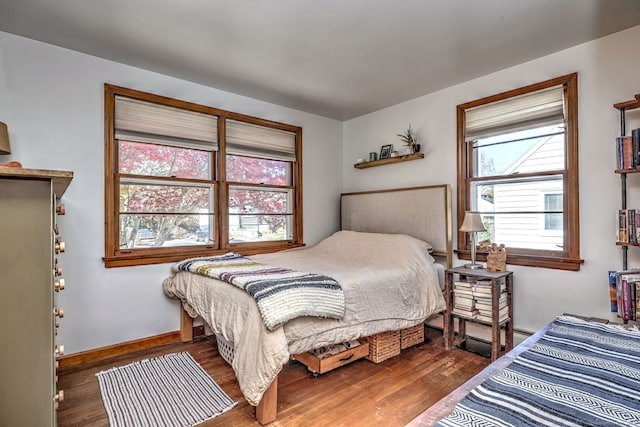 bedroom with multiple windows and dark wood-type flooring