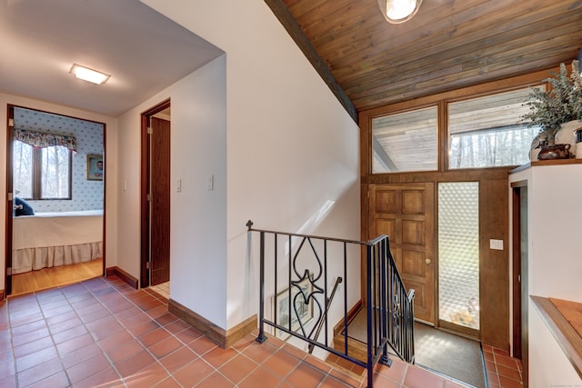 tiled entryway featuring lofted ceiling, a wealth of natural light, and wooden ceiling