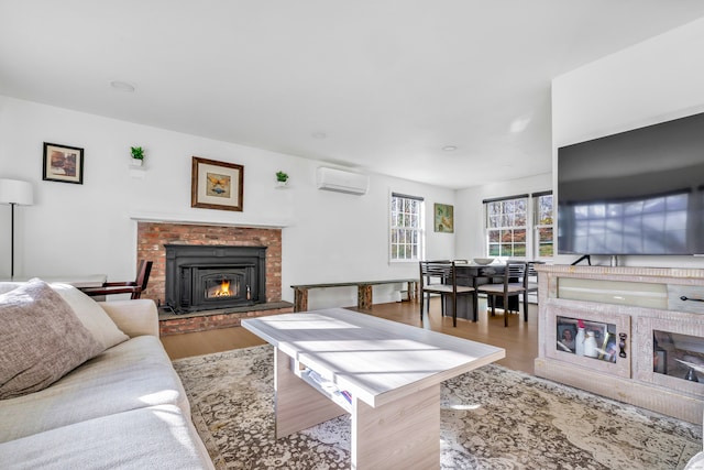 living room with an AC wall unit, a fireplace, and light wood-type flooring