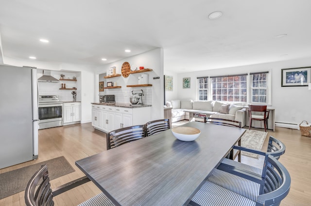 dining room with a baseboard radiator and light hardwood / wood-style flooring