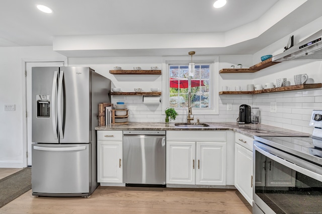 kitchen featuring backsplash, sink, light hardwood / wood-style floors, white cabinetry, and stainless steel appliances