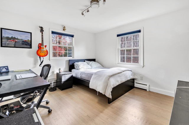 bedroom with baseboard heating and light wood-type flooring