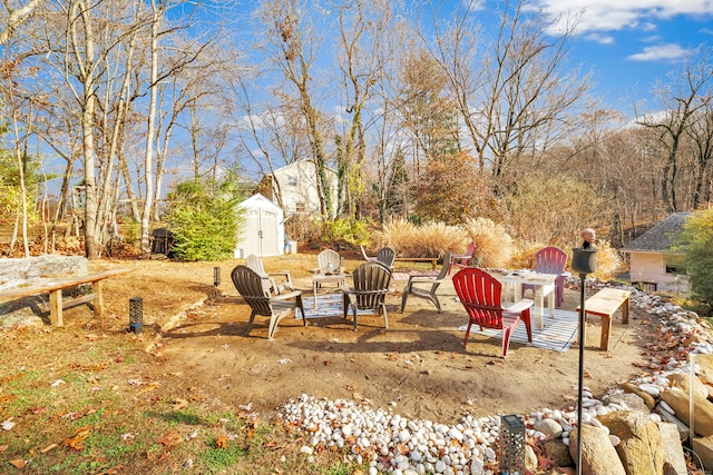 view of yard with a shed and an outdoor fire pit