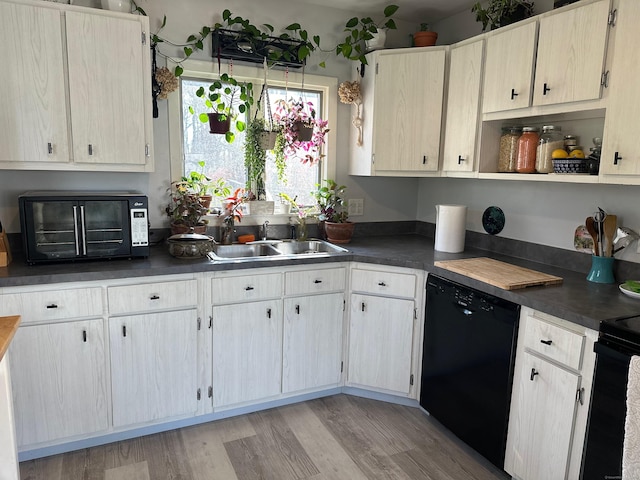 kitchen featuring sink, black appliances, and light hardwood / wood-style floors