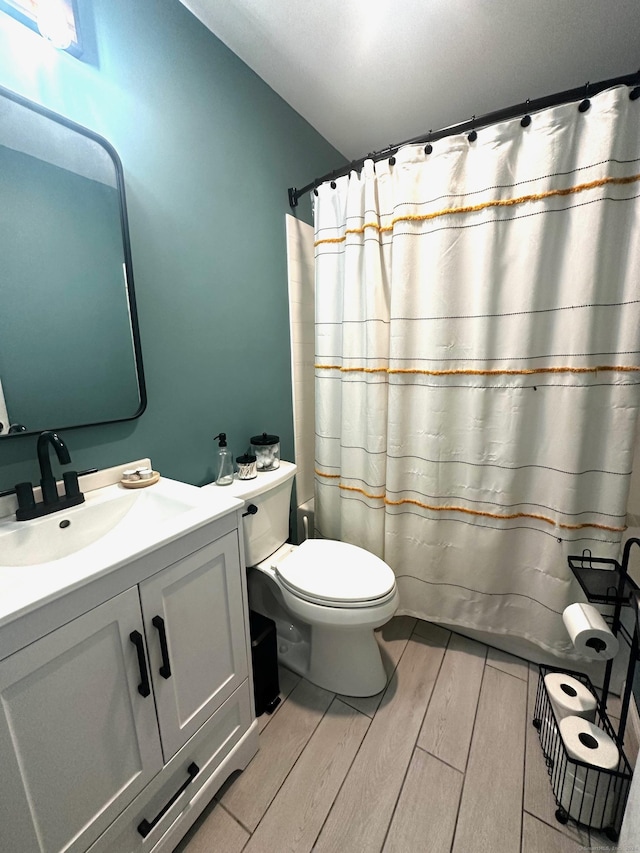 bathroom with vanity, curtained shower, and toilet