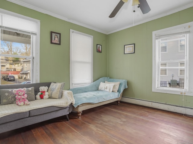 bedroom featuring ornamental molding, a baseboard heating unit, wood-type flooring, and ceiling fan