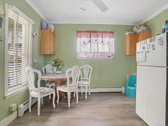 dining room with a textured ceiling, crown molding, ceiling fan, and light hardwood / wood-style flooring