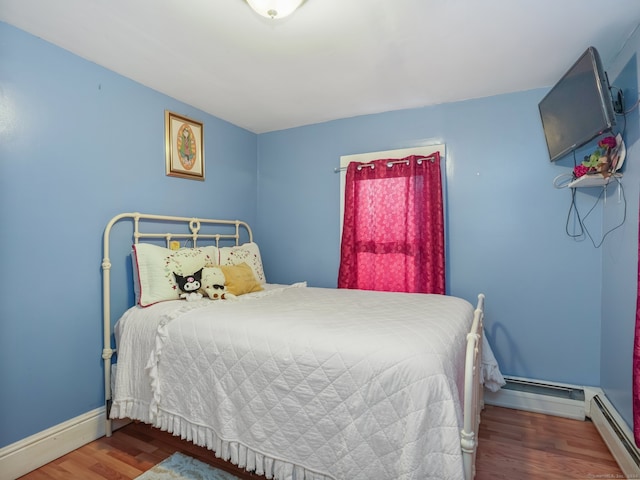 bedroom with a baseboard radiator and wood-type flooring