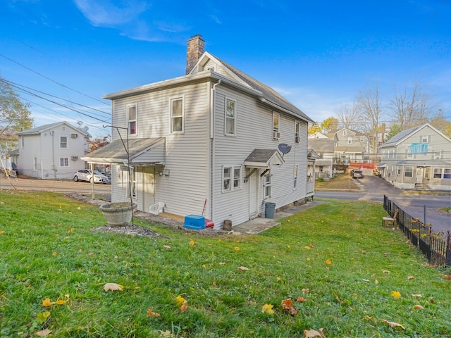 rear view of property featuring a yard